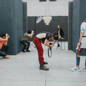 A group of photographers captures a model in a modern indoor studio setting.